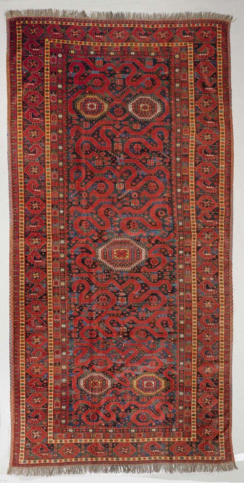 BESHIR antique.Red ground with five small medallions, geometrically patterned, dark border with red blossoms, in good condition, 175x370 cm.