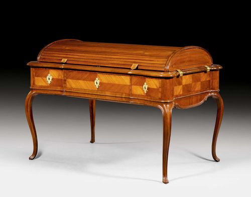 PRINCELY WRITING DESK WITH COVERED CYLINDER, attributed to Louis XV, M. BAUER (Johann Michael Bauer, Westheim 1710-1789 Bamberg), Bamberg ca. 1765/70. Mahogany in veneer, inlaid with reserves. Curved top with coverable cylinder and hinged lateral supports, curved legs. Front with wide central drawer, and one smaller drawer on each side. Gilt bronze mounts, not original. With label &quot;Schloss Baden Inventar S. 345, Nr. 1&quot;. 137x89.5x79.5 (with cylinder 95 cm). Provenance: -formerly in the collections of the Princes of Baden-Baden in the Neue Schloss. - Auction Sotheby&#39;s &quot;in situ&quot;, 10-20 September 1995 (Lot No. 6647). - from an English collection.