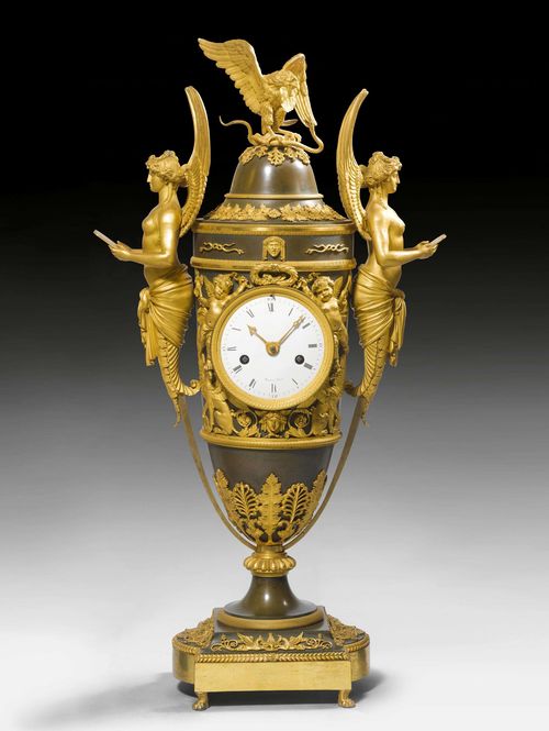 MANTEL CLOCK &quot;AUX VICTOIRES&quot;, Empire, the dial signed MANIERE A PARIS (Charles-Guillaume Hautemani&#232;re, ma&#238;tre 1778), Paris ca. 1805/10. Gilt and burnished bronze. Enamel dial. 2 small gilt hands. Parisian movement striking the 1/2-hours on bell. Gilt mounts and applications. Requires servicing. H 63 cm. Provenance: - from a Swiss private collection.
