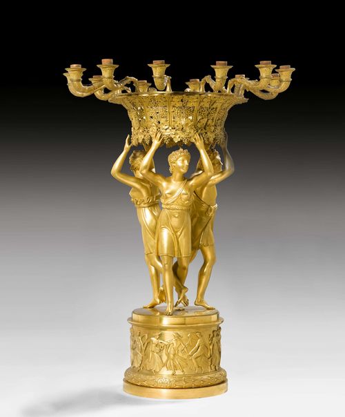 TABLE ORNAMENT "AUX BACCHANTES", Empire, signed J.G. DANNINGER A VIENNE (Johann Georg Danninger, died 1848), after designs by P.P. THOMIRE (Pierre Philippe Thomire, 1751 Paris 1843), Paris ca. 1815/25. Gilt bronze. Fitted for electricity. H 78 cm. Provenance: - from a Swiss private collection.