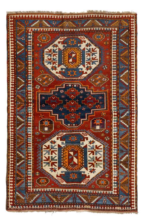 KAZAK old. Red ground with three large medallions in white and blue, geometrically patterned, blue edging, slight wear, 150x218 cm.