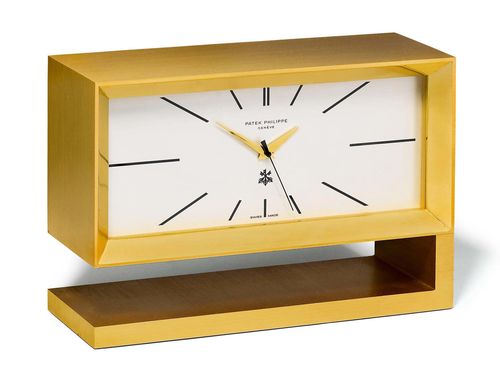 PATEK PHILIPPE, RARE TABLE CLOCK WITH ORIGINAL CERTIFICATE, 1974. Gold-plated brass. Ref. 1160. Mint condition, unusual table clock with gold-plated brass case and silvered dial, baton indices and gold Dauphine hands, central second, signed Patek Philippe and with the logo of the Swiss Bank Corporation. Early quartz movement, developed by Patek Philippe, similar to the &quot;Chronotome C&quot; type. The 10-kHz quartz frequency is reduced to 1 Hz, and is then amplified. This current drives a step motor, with the second hand jumping precisely every second. These clocks were produced in 1974 in a very limited series for the 75-year jubilee of the Swiss Bank Corporation. Case No. 1.800.129. D 145 x 210 mm. With original certificate and instructions. Sold by Chronometrie Beyer, 7 September 1974.