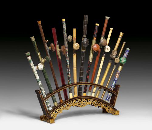 13 FINE OPIUM PIPES IN VARIOUS MATERIALS. China, 19th and 20th century, length max. 63.5 cm. Wood stand. Few damages and repairs. (13)