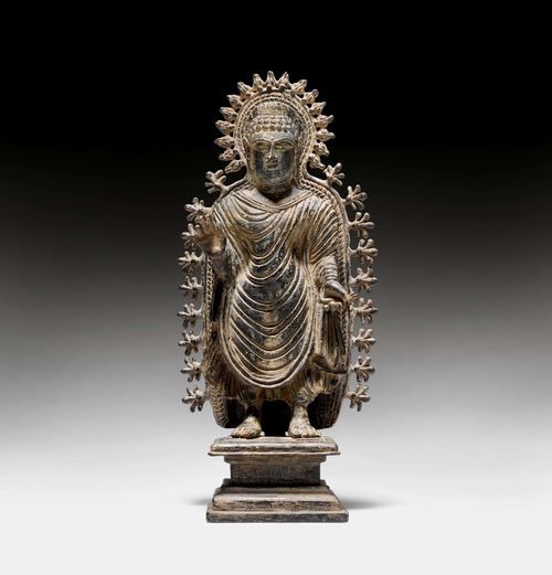 A RARE BRONZE FIGURE OF THE STANDING BUDDHA WITH AUREOLE. Gandhara, 6th c. H 27 cm. Inlaid eyes. Repatinated in the 19th or 20th c.