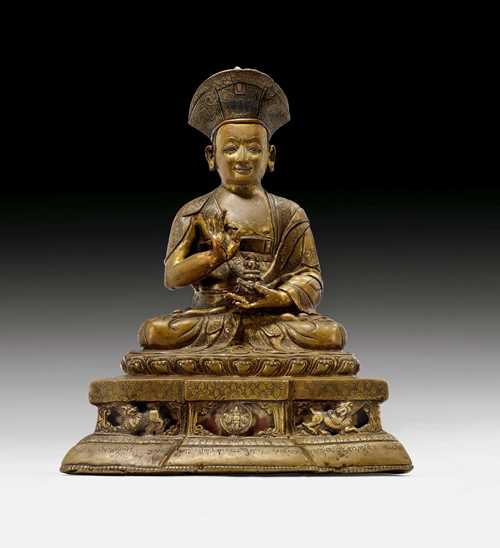 A FINE BRONZE FIGURE OF A HIGH RANKING KAGYU-MONK. Tibet, 16th c. Height 22 cm. Silver and copper inlays. Inscription.
