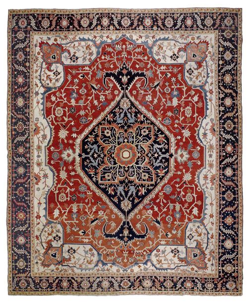 HERIZ SERAPI antique.Attractive collectors' item in good condition. Floral central medallion in dark blue and pink on a red and white ground. The entire carpet is beautifully patterned with stylised trailing flowers in harmonious colours. Black border. 356x295 cm.