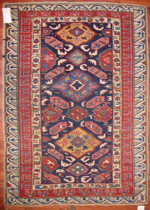 SEICHUR antique.Blue ground, geometrically patterned in harmonious colours, red and white border, strong signs of wear, 170x120 cm.