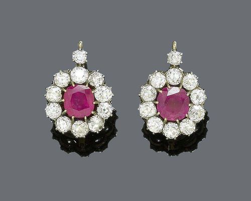 BURMA RUBY AND DIAMOND PENDANT EARRINGS, Vienna, ca. 1900. Silver over pink gold. Fancy pendant earrings with hook mechanism, set with 2 fine, red Burma rubies weighing ca. 4.80 ct, untreated, within a border of 11 old european cut diamonds each, weighing ca. 3.00 ct. Maker's mark JF. With Gemlab Report No. 1967/09. In contemporary case from J.F. Wrana, Jeweller, Stallburgstrasse, Vienna.