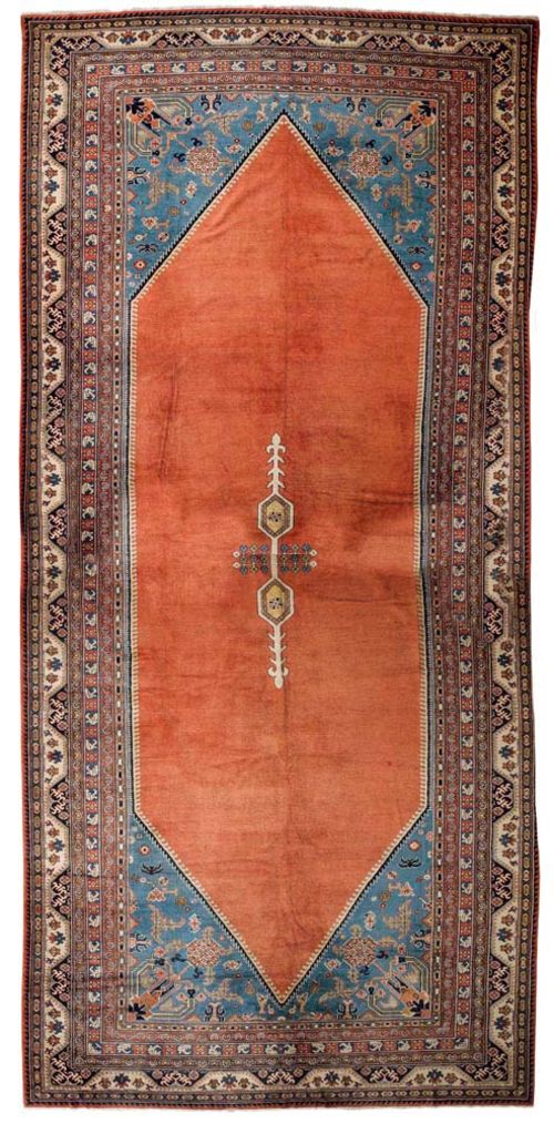ANATOLIAN ca. 1930.Blue central medallion on a rust coloured ground with blue corner motifs, the entire carpet is geometrically patterned with stylized plant motifs, wide border, good condition, 780x280 cm.