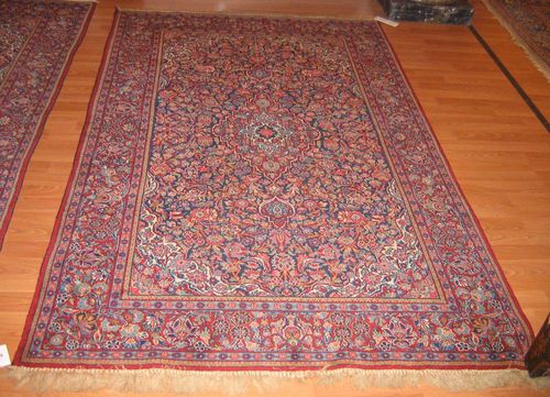 A PAIR OF 2 KESHAN CARPETS old.Blue central field with a red and white central medallion and corner motifs, the entire carpet is florally patterned, red border, good condition, 130x215 cm.