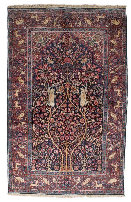 KIRMAN LAVER antique.Blue mihrab with red spandrels, finely patterned with depictions of plants and animals in harmonious colours, red border, good condition, 140x215 cm.
