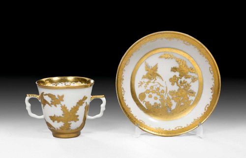 BEAKER AND SAUCER WITH "FELS-UND-VOGEL" DECORATION, Meissen, circa 1730-35.Painted in underglaze blue and gold overpainting, also with etched decoration, from an Augsburg Hausmaler workshop probably by Abraham Seuter. Underglaze blue sword marks and  double ring borders, blue painter's mark .