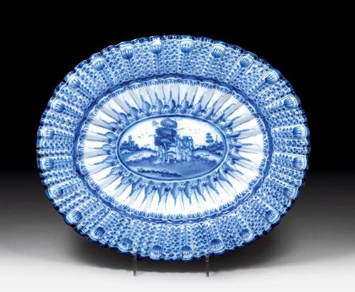 LARGE OVAL FACETTED DISH, Hanau, circa 1700.Painted in blue on a light blue ground with central Biblical scene.