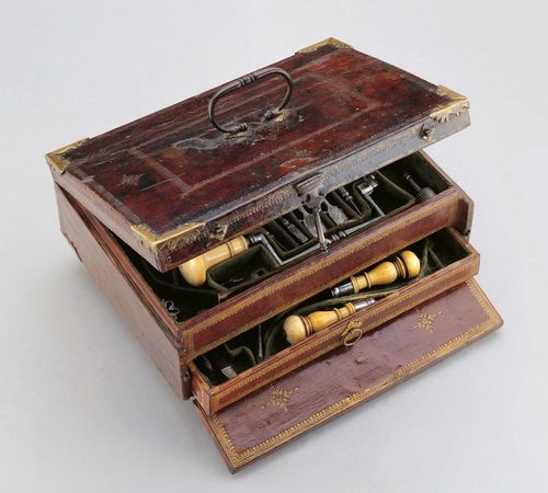 A FRENCH TREPANNING SET, 18th c. Shaped steel and turned ivory handles. Comprising a trepan with various drilling bits, elevators, scalpels, etc. The majority of the instruments marked with a lobster. In with red maroquin covered case and green velvet lining. 30x22.5x10 cm. 1 key. Partly associated.