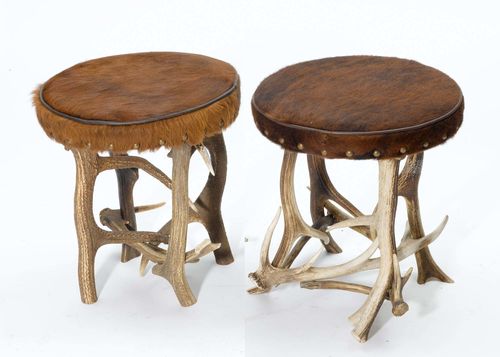PAIR OF ANTLER STOOLS,in the rustic style. Round, cushioned stool covered with brown cow hide, antler legs.
