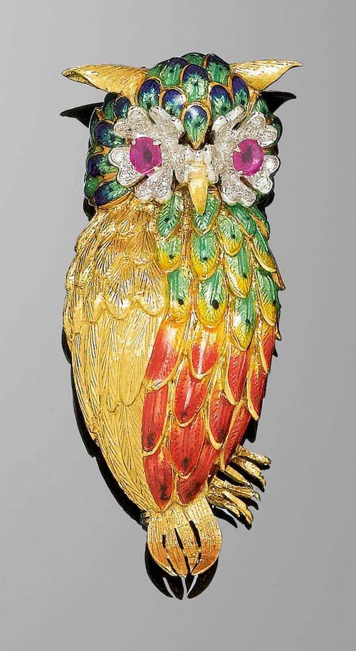 ENAMEL, RUBY AND DIAMOND CLIP BROOCH, ca. 1950. Yellow gold 750, 37g. Decorative brooch in the shape of an owl, the body and head with polychrome, translucent enamel. The eyes set with 2 round rubies totalling ca. 0.70 ct and surrounded by a total of 30 brilliant-cut diamonds totalling ca. 0.50 ct.