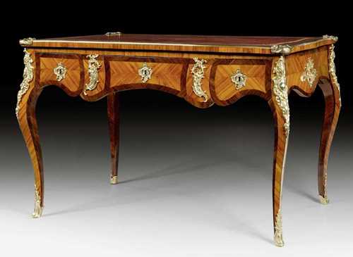 BUREAU-PLAT,Louis XV, in the style of J. DUBOIS (Jacques Dubois, maitre 1742), Paris circa 1750/55. Tulipwood and rosewood veneer. The top lined with red leather, the frieze in "contour à l'arbalète". With 3 drawers at the front and the same but sham arrangement verso. Gilt bronze mounts and sabots. Requires some restoration. 119x74x77.5 cm. Provenance: Private collection, Basel.