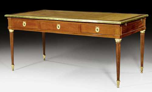 BUREAU PLAT,Louis XVI, stamped G. IACOB (Georges Jacob, maitre 1765), Paris circa 1780. Fluted mahogany. The top lined with gold-stamped brown leather and edged in bronze. Same, but sham arrangement verso. Pull-out shelf on each side. Finely gilt bronze mounts and sabots. 162x81x75 cm.