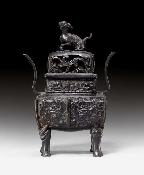 CENSER.China, Qing dynasty, 26x15x10 cm. Bronze. Vessel of a rectangular shape with a contracted neck. The four legs spring from animal masks. Openwork cover with Fo Dog knop. On the vessel walls two taotie masks, on the neck highly stylised dragons. "Yu Tang Qing Wan" mark on the bottom (mark of Yan Donglou, 1513-1565), but later.