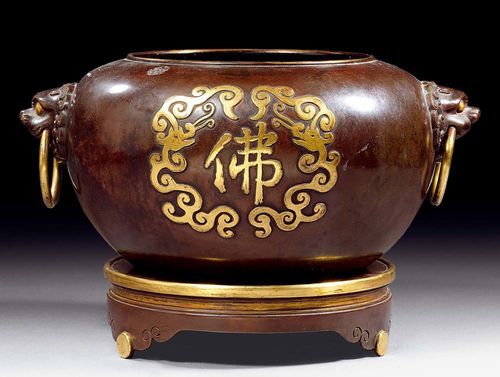 LARGE INCENSE BURNER ON A STAND.China, 18th century. D (including handles) 35 cm. Dark,  patinated copper with two gilded "fo" (Buddha) characters in a stylized dragon surround on the outer wall. There are lion heads with ring-shaped handles on both sides. Matching stand on three legs. Seal mark.