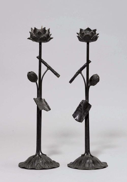 TWO CANDLESTICKS.Japan, 19th c. H 54 cm. Bronze. In the form of lotus flowers on stems, each with a bud and two leaves. (2)