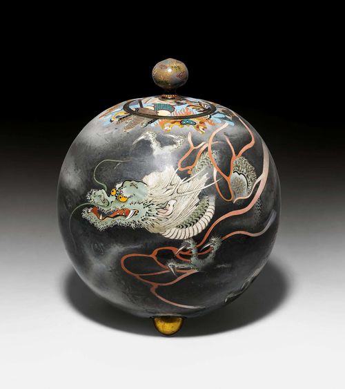 SPHERICAL CLOISONNÉ VASE WITH LID.Japan, Meiji period, H 39 cm. A bright yellow dragon emerges dynamically through grey clouds. The lid with bud-shaped knop is decorated with musical instruments on a turquoise ground, which extend beyond the lid. On three ball feet. Min. damage.