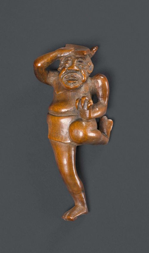 NETSUKE OF A DANCING ONI.Japan, 19th/20th c. H 10 cm. Wood. The loudly singing demon swings his leg and a fan over his head.
