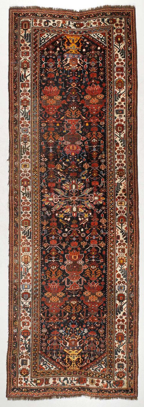 GASHGAI antique.Dark blue ground, opulently patterned with colourful flower motifs, white border, slight wear, 105x310 cm.