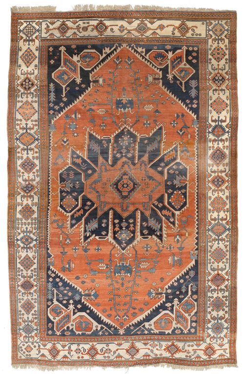 HERIZ antique.Bulky central medallion in blue and rust-red on a rust-red ground with blue corner motifs, the entire carpet is geometrically patterned with stylised plant motifs, wide border in white, signs of wear, 325x493 cm.