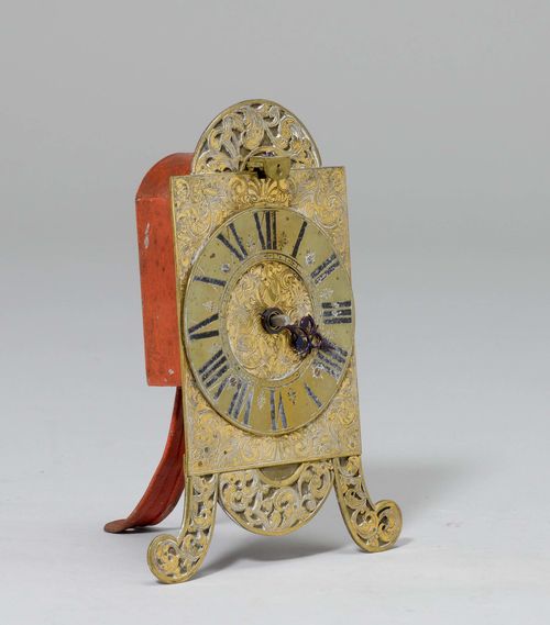 ‘VORDERZAPPLER’ CLOCK, Southern Germany, 18th century. Brass. Rectangular, opulently engraved fronton on front volute feet. Engraved dial ring. Movement with verge escapement. H 18 cm. Requires restoration.