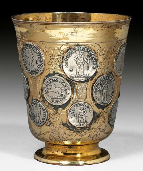 BEAKER WITH COINS. Vermeil. Berlin 2nd half of the 18th century.Maker's mark Gebrueder Mueller. Gilt all around, with floral décor and inserted Marien-Grosch coins. H: 9.5 cm. Wt.: 140 g.