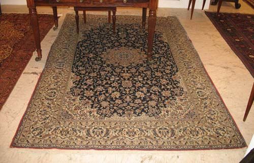 NAIN.Blue central field with beige central medallion and white corner motifs, patterned with tendrils and palmettes. Good condition, 255x160 cm.