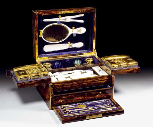 TOILETRY CASE. Silver-gilt. London, 1877/78.Extensive toiletry set. Consists of 11 cut glass boxes with silver-gilt covers, of various shapes and sizes, 2 large, cut-glass bottles with silver-gilt covers, 5 brushes, 1 mirror, 1 shoehorn and one ivory shoe stretcher. A velvet-lined secret drawer on the bottom. Several small instruments such as a pair of scissors, awls, etc. Box veneered with mahogany and rosewood. Provenance: Château de Vincy, Romandy.