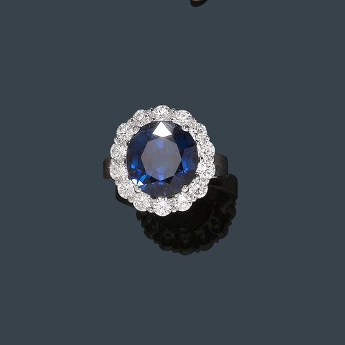 SAPPHIRE AND DIAMOND RING. White gold 750. Elegant ring, set with a sapphire of ca. 9.40 ct within a border of 14 brilliant-cut diamonds weighing ca. 1.67 ct. Size 53.5.