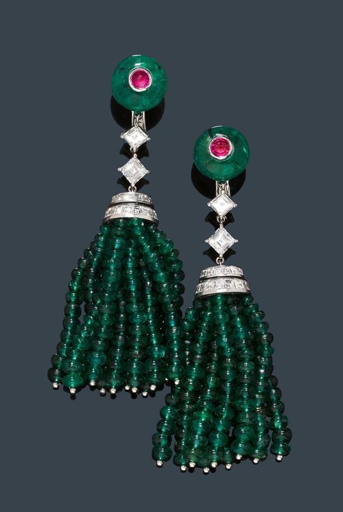 EMERALD, DIAMOND AND RUBY EAR PENDANTS, CARTIER. Platinum and white gold 750. Very fancy ear clips in the Art Déco style, each clip part of an emerald sphere of ca. 11.7 mm Ø, the centre set with a facetted ruby cabochon. Below, a tassel of emerald beads weighing ca. 90.00 ct with an attache set with diamonds, mounted below 2 square-cut diamonds. Total weight of the 64 square-cut diamonds ca. 3.50 ct., signed Cartier, No. 720220. L ca. 7 cm.