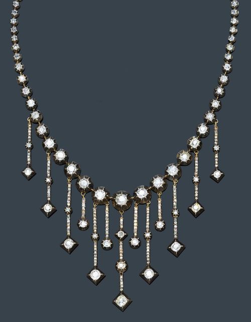 DIAMOND NECKLACE , probably France, ca. 1880. Silver over pink gold. Fancy Rivière necklace of 44 rose-cut diamonds and 23 graduated, old European-cut diamonds. The front decorated in a fringe-like manner with 13 pendants of different lengths adorned with 19 old European-cut diamonds and ca. 130 rose-cut diamonds in round and square box settings. Clasp decorated with an oval rose-cut diamond. Total weight of the diamonds ca. 8.00 ct. L ca. 36.5 cm.