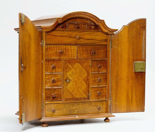 MINIATURE CABINET,Baroque. Walnut inlaid with geometric decoration. Rectangular body with double door, inside with 13 drawers and 1 door, behind the door, 3 further drawers. 41.5 x 30 x 35 cm.