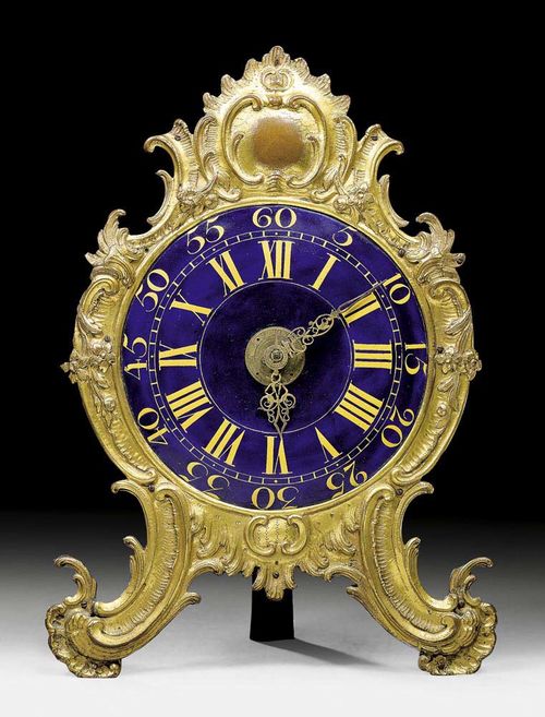 NIGHT CLOCK,Louis XV, the movement signed FRANZ XAVER GEGENREINER AUGSPURG (maitre 1760), Augsburg circa 1760. Bronze and brass. The cartouche shaped frame with medallion atop, on scrolled feet. The blue enamel dial with Arabic and Roman numerals. Brass movement striking on bell. In need of servicing. 21x8x30 cm.