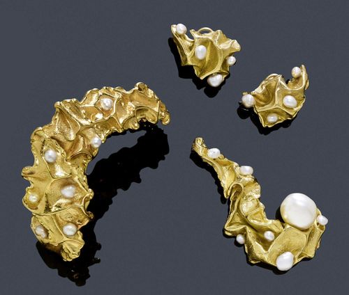 A PEARL AND GOLD ENSEMBLE, GILBERT ALBERT. Yellow gold 750, 94g. Fancy, asymmetrical, undulated bangle with a textured surface, the top set with 8 white and silver-grey Keshi pearls of ca. 4 - 5 mm, signed, ca. 6 x 5 cm. Matching decorative brooch set with 1 white cultured pearl of ca. 14 x 13 mm and 6 small white and silver-grey pearls, signed and numbered 4846, L ca. 6,2 cm. Matching ring, set with 3 pearls, size ca. 49 and matching ear clips set in total with 8 pearls. With case.