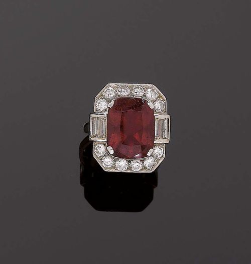 TOURMALINE AND DIAMOND RING, ca. 1935. Platinum 950. Classic model, the octagonal top set with 1 antique oval, red tourmaline of ca. 9.00 ct, slight signs of wear, flanked by 4 baguette-cut diamonds totalling ca. 0.50 ct and set with 12 brilliant-cut diamonds totalling ca. 1.00 ct. Size ca. 56.