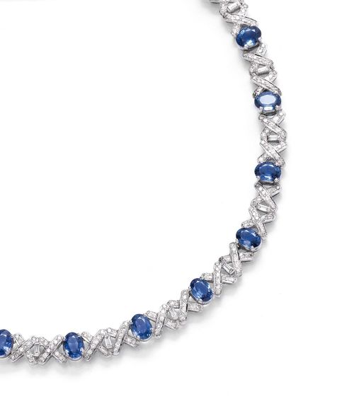 SAPPHIRE AND DIAMOND NECKLACE. White gold 750. Decorative necklace set with 22 oval sapphires weighing ca. 20.00 ct, interconnected by "X"-shaped motifs set with diamonds. In total 22 baguette-cut diamonds and 220 brilliant-cut diamonds weighing ca. 5.00 ct. L ca. 42 cm.