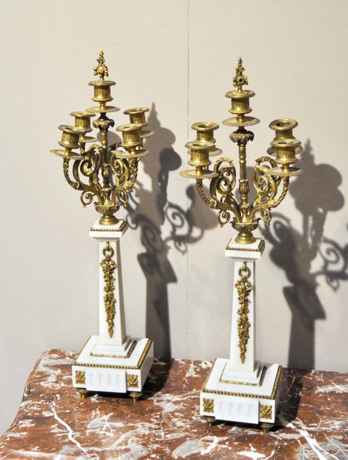 PAIR OF GIRANDOLES,Napoleon III, France. Bronze, brass and white marble. Conical shaft with pine cones as the lower part. 4 curved arms with round drip plates and cylindrical nozzles. On a rectangular base. H 60 cm.
