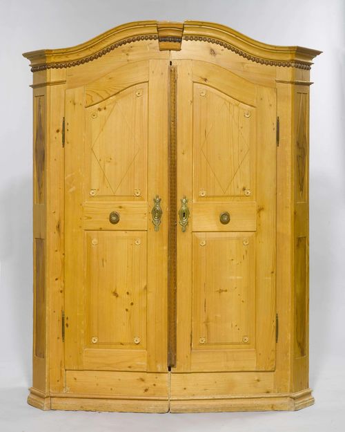 ARMOIRE FROM THE LAKE CONSTANCE REGION,Louis XVI, ca. 1800. Pine carved with rosettes, laurel and egg and dart. Rectangular body. Front with 2 doors curved on the top. Brass mounts. 152x50x190 cm. 1 key. Requires some restoration.