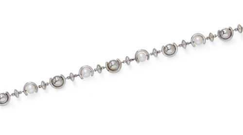 PEARL AND GOLD SAUTOIR, BUCHERER. White gold 750, 112g. Attractive sautoir of 18 Akoya cultured pearls of ca. 7.5 mm Ø in half-moon-shaped settings, with bead- and donut-shaped intermediate parts, and with an integrated clasp. L ca. 84 cm. With case.