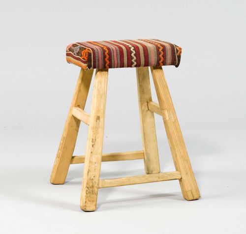 STOOL,in the rustic style. Wood. Rectangular, padded seat on inclined legs. Kilim cover.