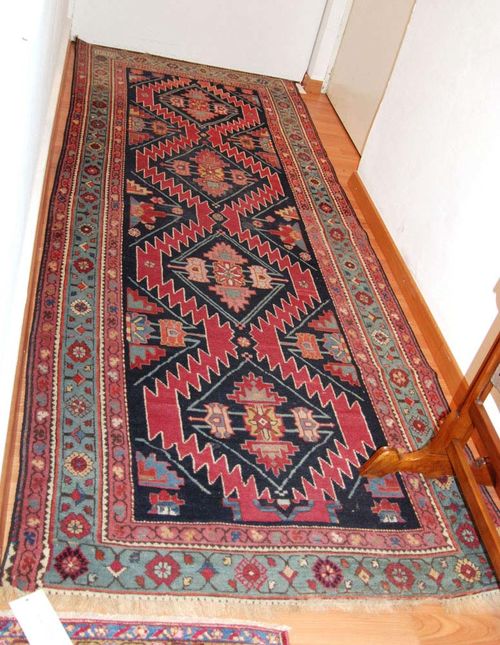 KARABAGH antique, signed.Dark blue ground with four lozenge-shaped medallions, geometrically patterned with stylized flowers, turquoise border, 275x103 cm.