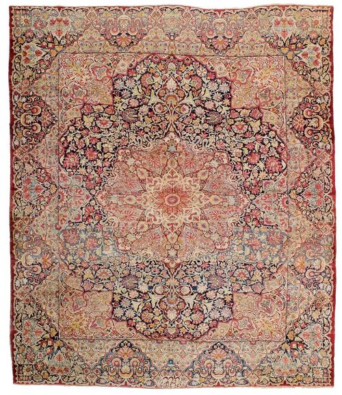 KIRMAN LAVER antique, signed.Dark blue central field with floral central medallion and corner motifs, the entire carpet is opulently patterned with trailing flowers in delicate shades of pink and green, broad border, signs of wear, 350x290 cm.