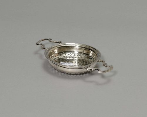 TEA STRAINER, probablyEngland 19th century. Maker's mark: EAEA. Round, with a stepped rim and two lateral handles. The walls engraved with a coat-of-arms. D 10.5 cm, 100 g.