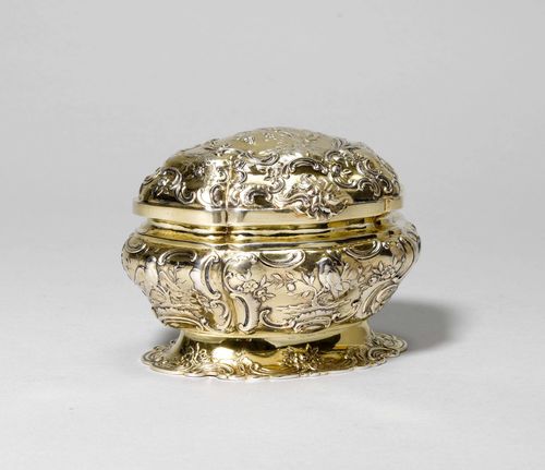 SILVER-GILT LIDDED BOX,Vienna 1st half of the 20th century. Mark: J. C. Klinkosch. Oval. On a curved foot decorated with volutes. The walls decorated with rocailles and birds. Matching hinged cover. H ca. 12.5 cm, 530 g.