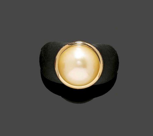 EBONY AND PEARL RING. Large decorative ebony ring, the top set with 1 natural colour yellow South Sea cultured pearl of ca 17.5 mm Ø in a yellow gold mount. Size ca. 58 With copy of receipt A.P. Berger/J. Frech, Zurich.